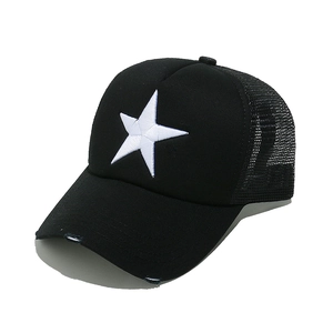 Detail of white star embroidery and distressed brim on a black mesh trucker hat