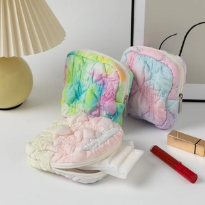 Detailed view of quilted bubble fabric pouches with metallic zippers in gradient colors