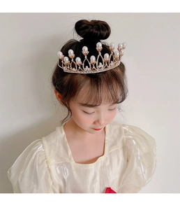 Detail of child wearing a princess crown with sparkling rhinestones and white pearls