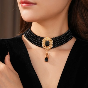 Detail of vintage black bead choker with ornate gold pendant and teardrop gem