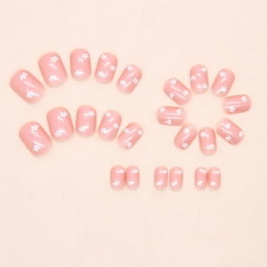 Kit de faux ongles courts carrés avec motifs floraux blancs délicats sur base rose clair