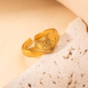 Detailed view of an adjustable gold titanium steel ring with eye and heart motifs