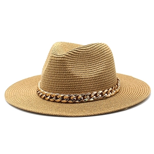 Close-up of brown straw fedora hat featuring a chunky gold metal chain link band