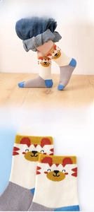 Detail showing beige cotton kids socks with cute brown bear and blue toe accents