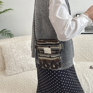Detail showing the snap button closure and plush material of this heart crossbody bag