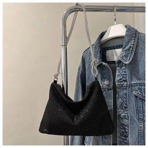 Detail of black rhinestone hobo bag with silver chain strap and stylish knot design