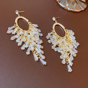 Elegant gold oval earrings with tassels and sparkling crystals in a high-fashion style