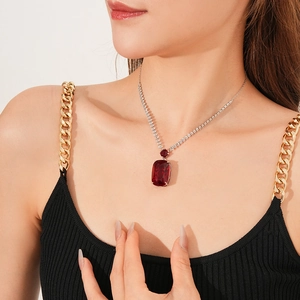 Macro view of luxury square red gemstone pendant with silver diamond chain on neck