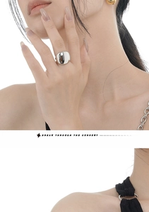 Macro di un anello aperto minimalista in argento lucido indossato da una modella