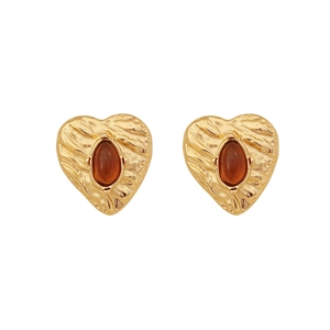 Vintage gold heart studs with amber gemstone and radiant texture on white background