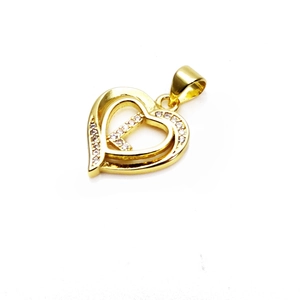 Macro detail of a gold heart pendant featuring sparkling cubic zirconia and bail