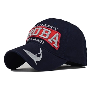 Detail of embroidered Aruba logo and white shark motif on navy blue cotton baseball cap