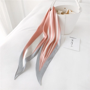 Pink and grey striped silk twilly scarf elegantly tied on a white designer handbag handle