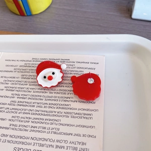 Vue détaillée de boucles d'oreilles Père Noël mignon avec finition émaillée rouge et blanc