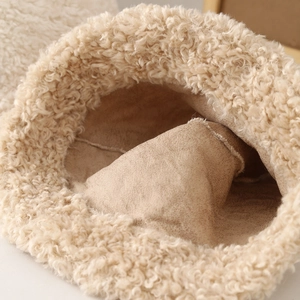 Macro detail of plush lamb wool texture and fine suede lining of a warm beige aviator hat
