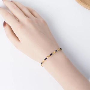 Detailed macro view of S925 silver gold-plated bracelet with blue square zircon stones