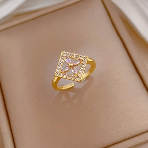 Detail of gold square flower ring with pink petals and zircon on warm jewelry box