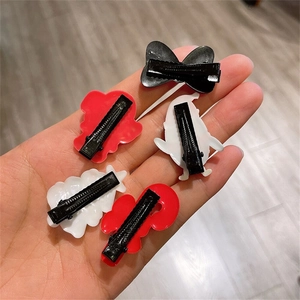 Handheld view of 5-piece Christmas hair clips with black metal alligator base