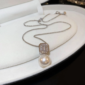 Gros plan du pendentif en zircon avec une grande perle ronde sur une chaîne en argent