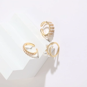Three-piece set of 14K gold plated pearl and zircon rings on white geometric stands