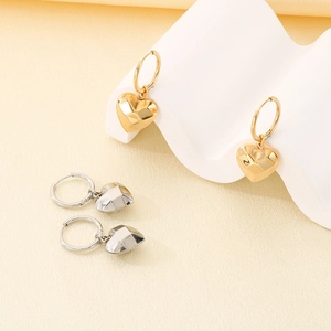 Detail shot of 3D geometric heart earrings in polished gold and silver metallic finishes