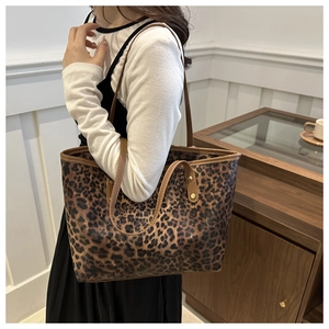 Close-up of leopard print tote bag on shoulder showing soft texture and spacious design