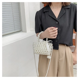 Détail du sac panier en perles tissées avec nœud en soie blanc et bandoulière élégante