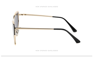 Detail view of gold metal cat-eye sunglasses with sleek frame and dark lenses
