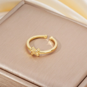 Detailed view of a gold-plated adjustable X-shaped ring with micro-pave cubic zirconia