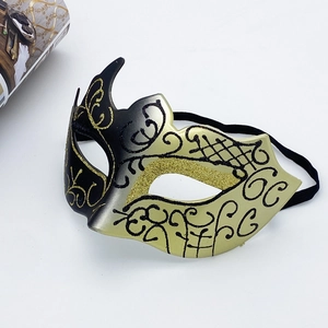 Detailed view of Venetian half-face mask with black and gold glitter flower patterns