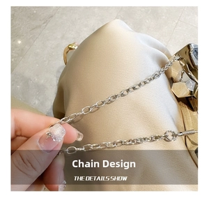 Macro detail of silver metal chain strap on a luxury sparkling champagne evening bag