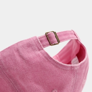 Détail arrière de casquette en coton rose délavé avec boucle réglable en bronze