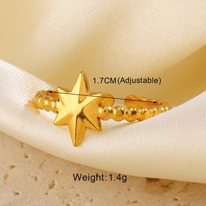Macro shot of gold star-patterned adjustable ring on silk fabric with size details