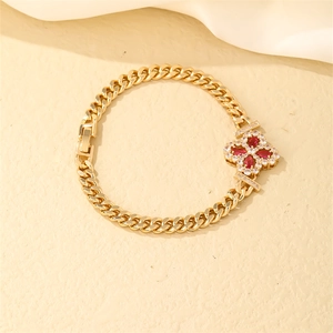 Close-up of gold-plated Cuban bracelet with red marquise stone flower and zircons