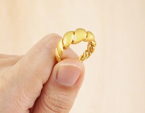 Close-up of a 18K gold plated chunky twisted ring with a polished surface and texture
