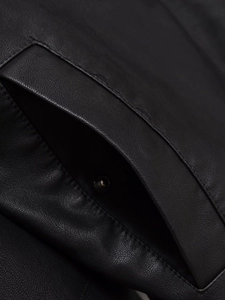Détails des coutures et du bouton-pression en métal sur la poche d'un blouson noir