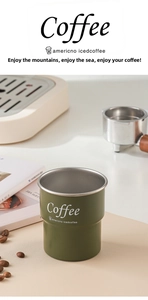 Detailed view of a dark green stainless steel coffee cup with a rolled rim and white text