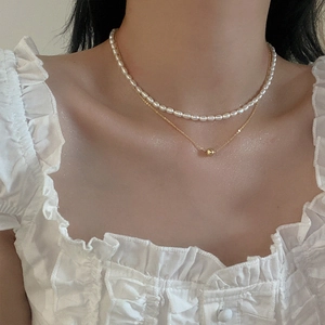 Close-up of elegant double-layered freshwater pearl necklace with gold bead pendant