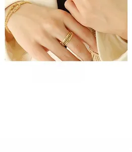 Detail of gold chain textured ring and twisted bracelet on hand, french retro style