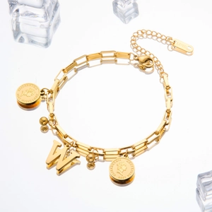 Detail of gold titanium steel bracelet featuring Elizabeth coin and W letter charms