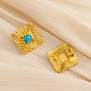 Gros plan détaillé de boucles d'oreilles vintage dorées avec pierres turquoise bleues