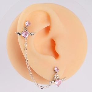 Close-up of pink heart zircon angel wing earrings with chain on silicone ear model