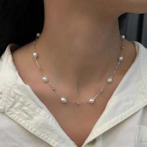 Close-up of baroque freshwater pearl choker necklace on a model for minimalist style