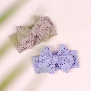 Detail of baby bow headbands in khaki and lavender with breathable eyelet fabric texture