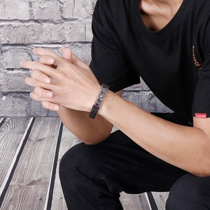 Detail of men's punk style woven leather and stainless steel chain bracelet on wrist