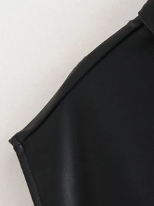 Close-up of black faux leather vest showing matte texture and fine stitching detail