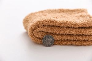 Close-up of thick brown coral fleece socks showing soft fluffy texture and material depth