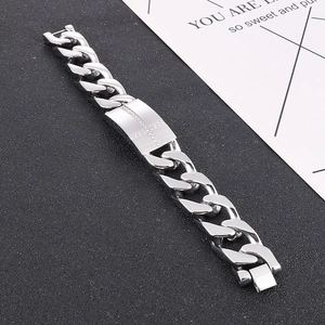 Détail de la chaîne gourmette argentée avec un pendentif croix serti de diamants brillants