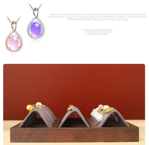 Detail view of walnut wood earring holder with gray velvet slots and teardrop crystal pendants