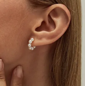 Elegant C-shaped pearl stud earrings for women with white round pearls and gold finish
